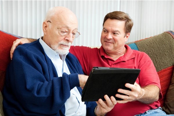 senior father adult son tablet couch home